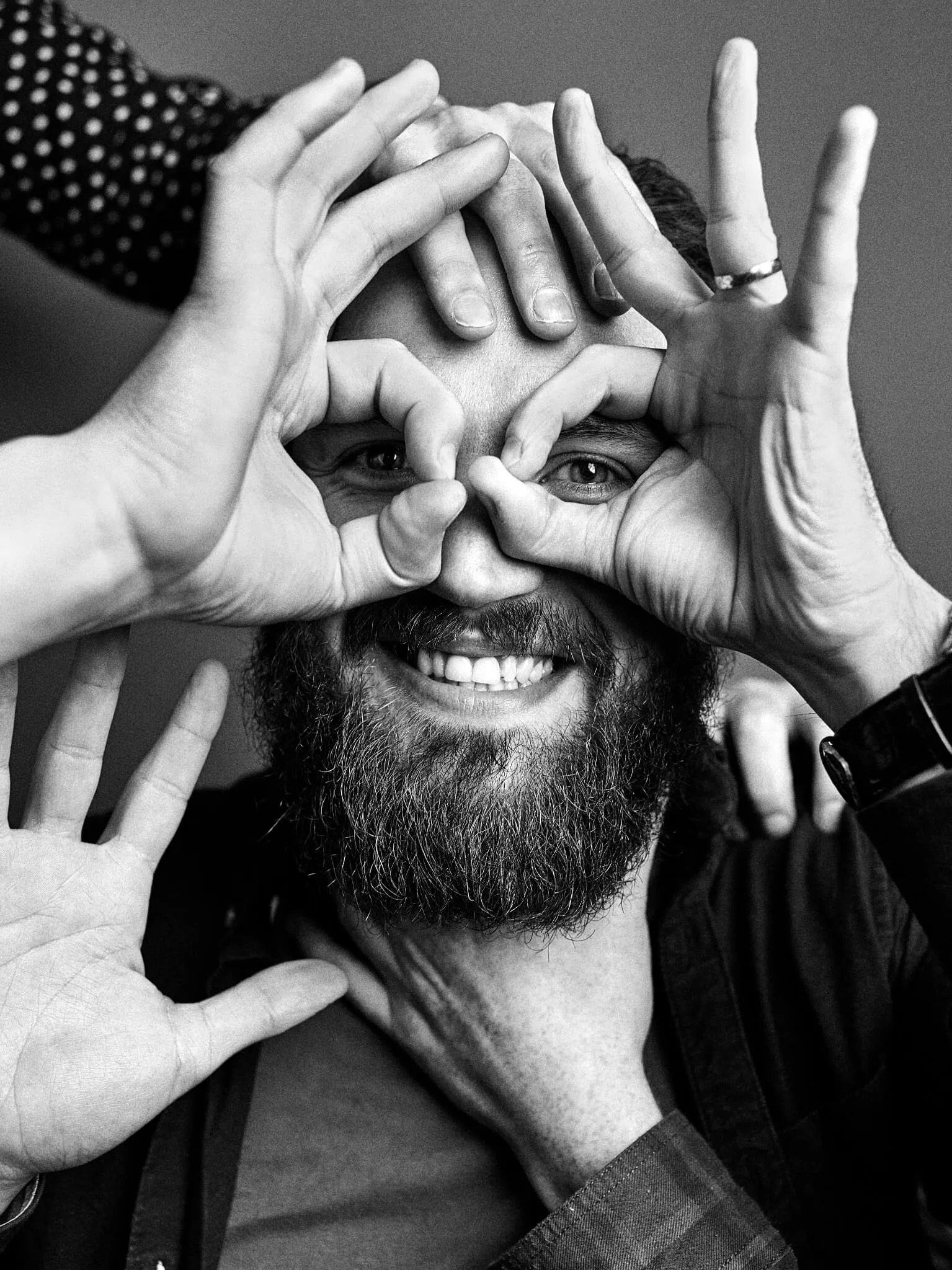 Robert Balfour, with his bandmates' hands making spectacles round his eyes